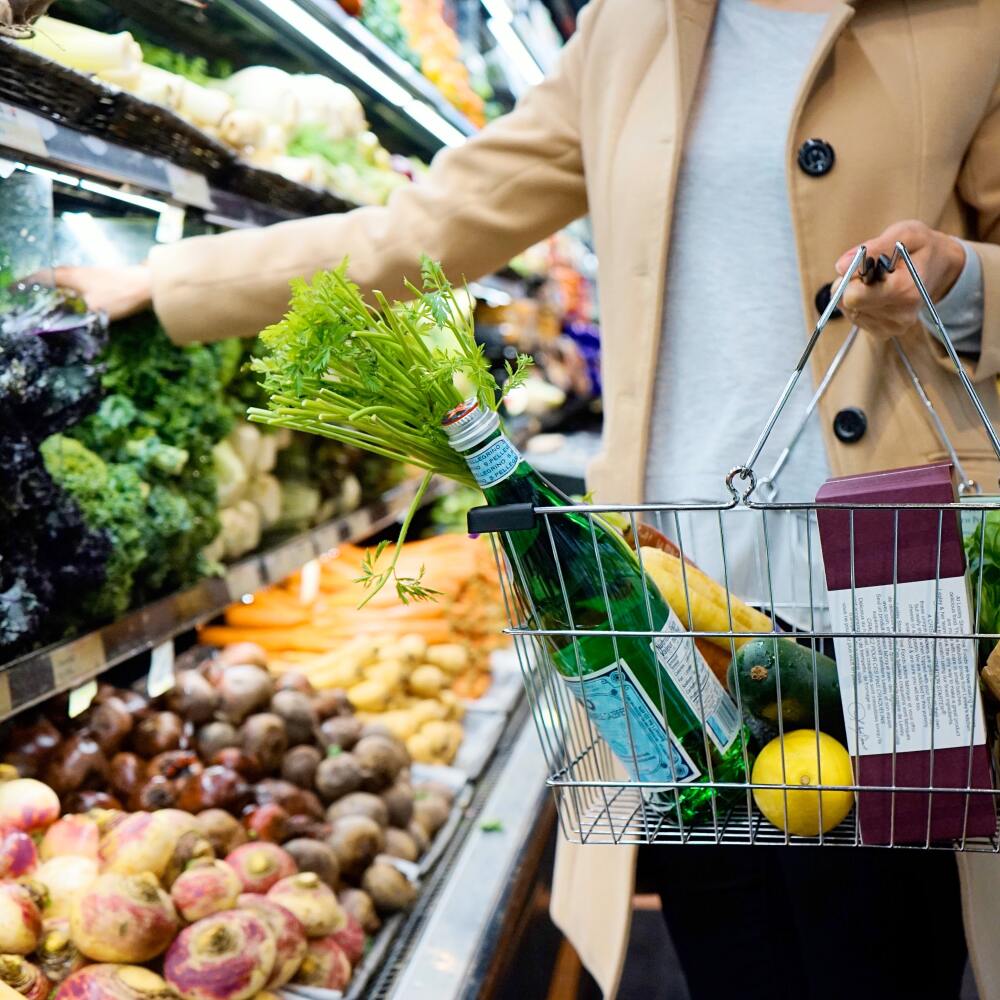 A person holding a grocery basket.